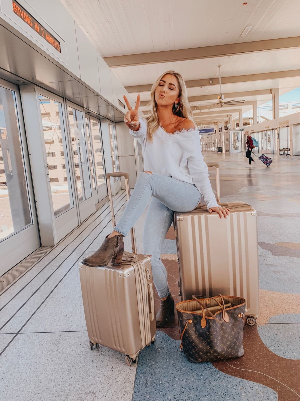 Traveller walking through a sunlit city with a suitcase